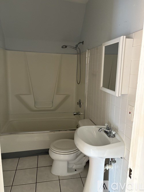 A white toilet and sink in a small bathroom.
