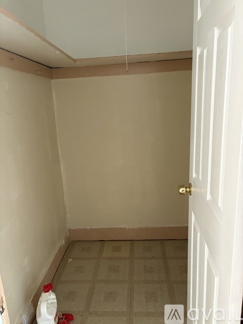 A room with a white door and a tiled floor.
