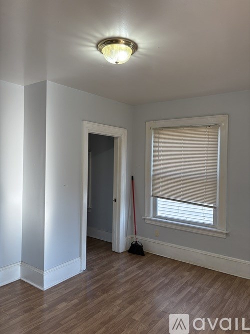 A room with a window and a broom is available for rent.