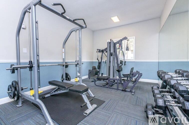 A gym with a variety of equipment including a leg press machine.