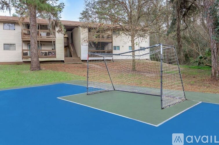 A tennis court is located in front of a building.