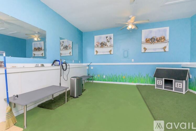 A room with blue walls and a green floor has a white table and a broom.