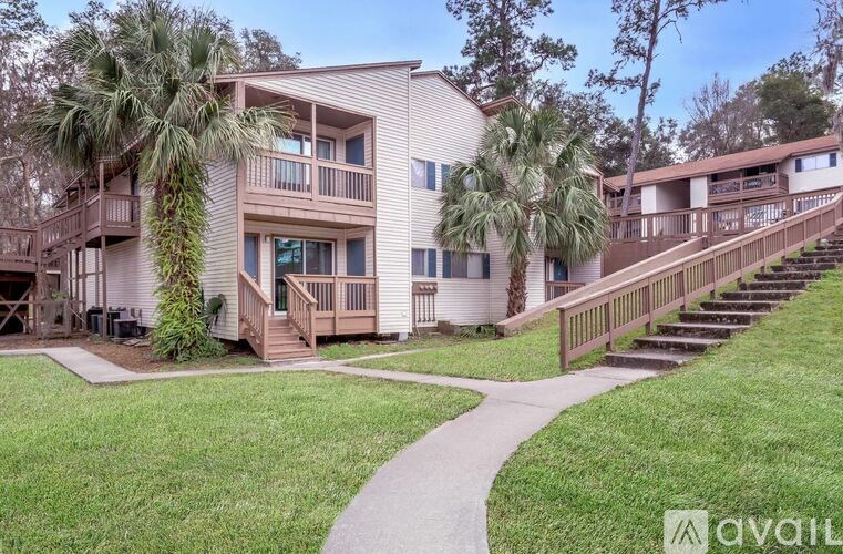 A building with a balcony and a tree in front of it.