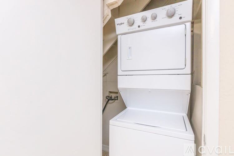 A white dishwasher is sitting in a kitchen.