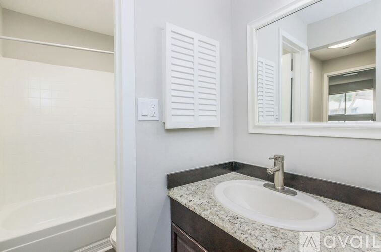 A bathroom with a sink, mirror, and a white towel rack.