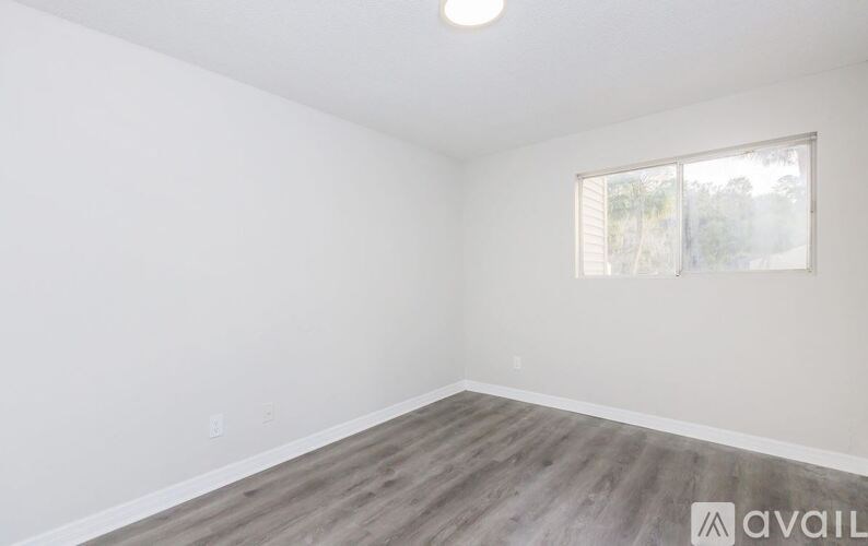A room with a window and wooden flooring is available for rent.