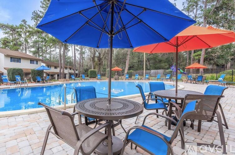 A blue umbrella is open over a table with chairs around it.
