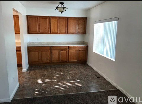 A kitchen with wooden cabinets and a marble floor.