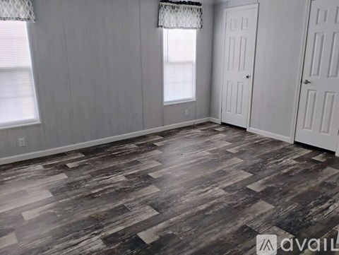 A room with wooden flooring and white doors.