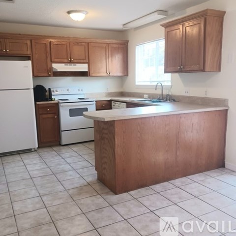 A kitchen with wooden cabinets and a white refrigerator.