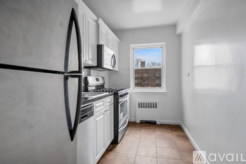 A kitchen with white cabinets and black appliances.