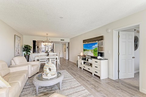 A living room with a white couch, a coffee table, and a painting on the wall.