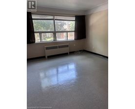 A room with a window and a radiator on the floor.