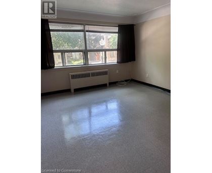A room with a window and a radiator on the floor.