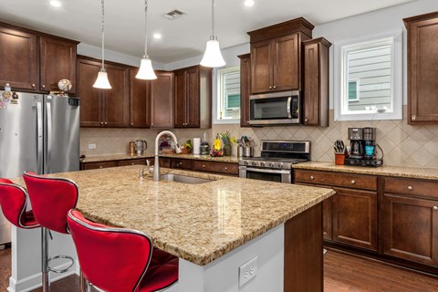A kitchen with brown cabinets and a granite countertop.