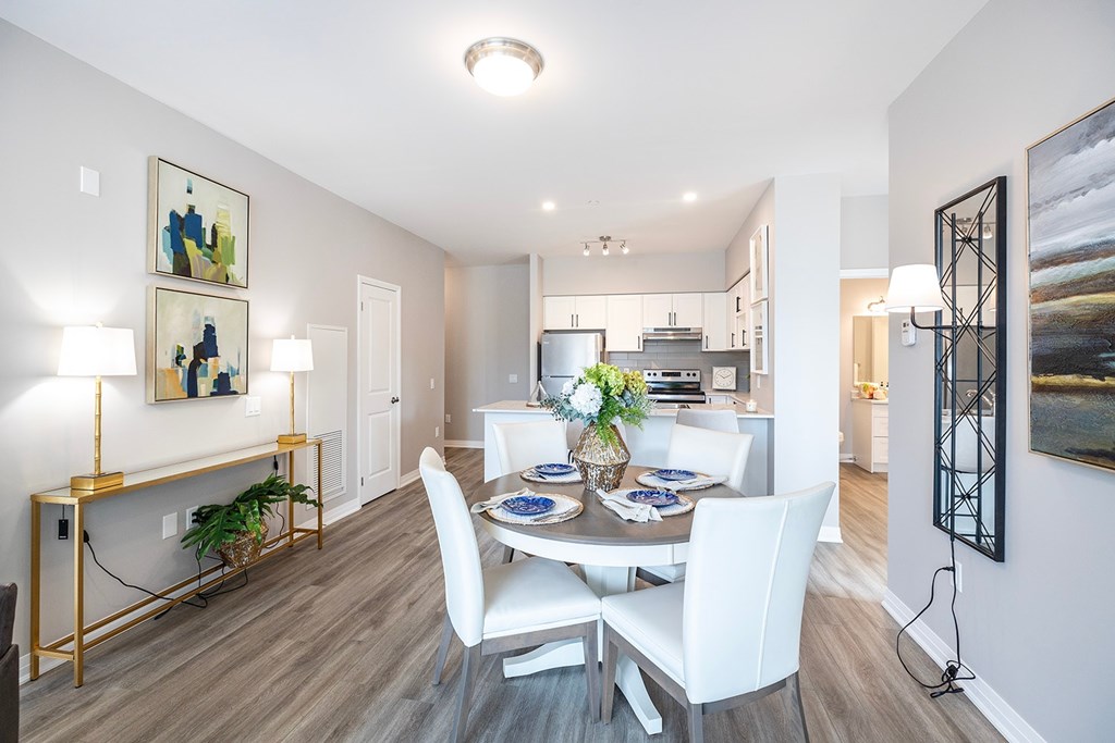 A dining room with a white table and chairs.