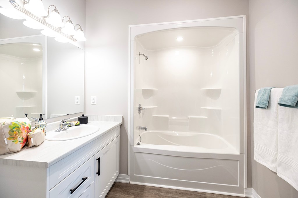 A white bathroom with a white tub and sink.