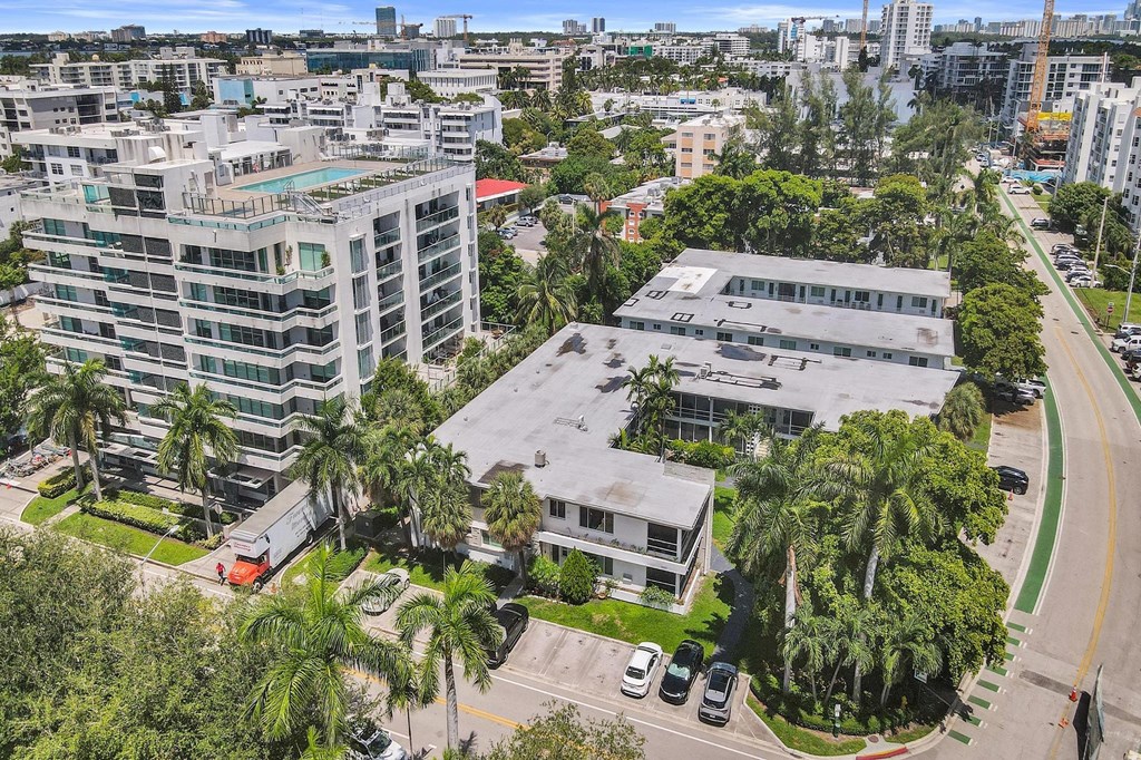 A view of a city with buildings, trees, and cars from an aerial perspective.