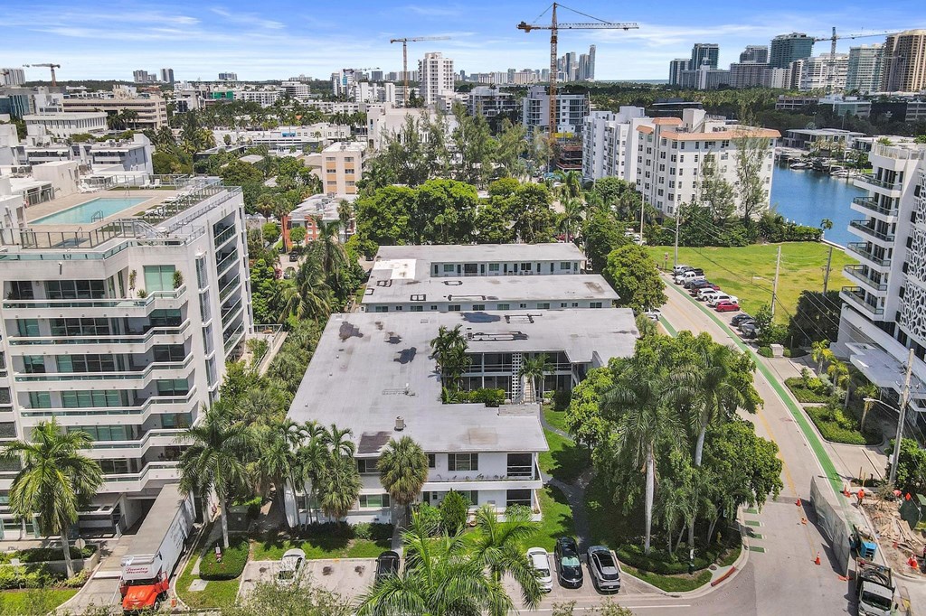A view of a cityscape with buildings, trees, and a body of water.