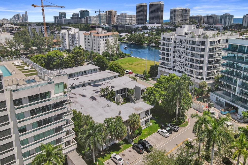 A view of a cityscape with buildings, cars, and a body of water.