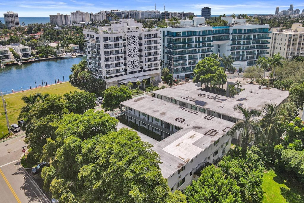 A view of a city from a high vantage point with buildings, trees, and a body of water.