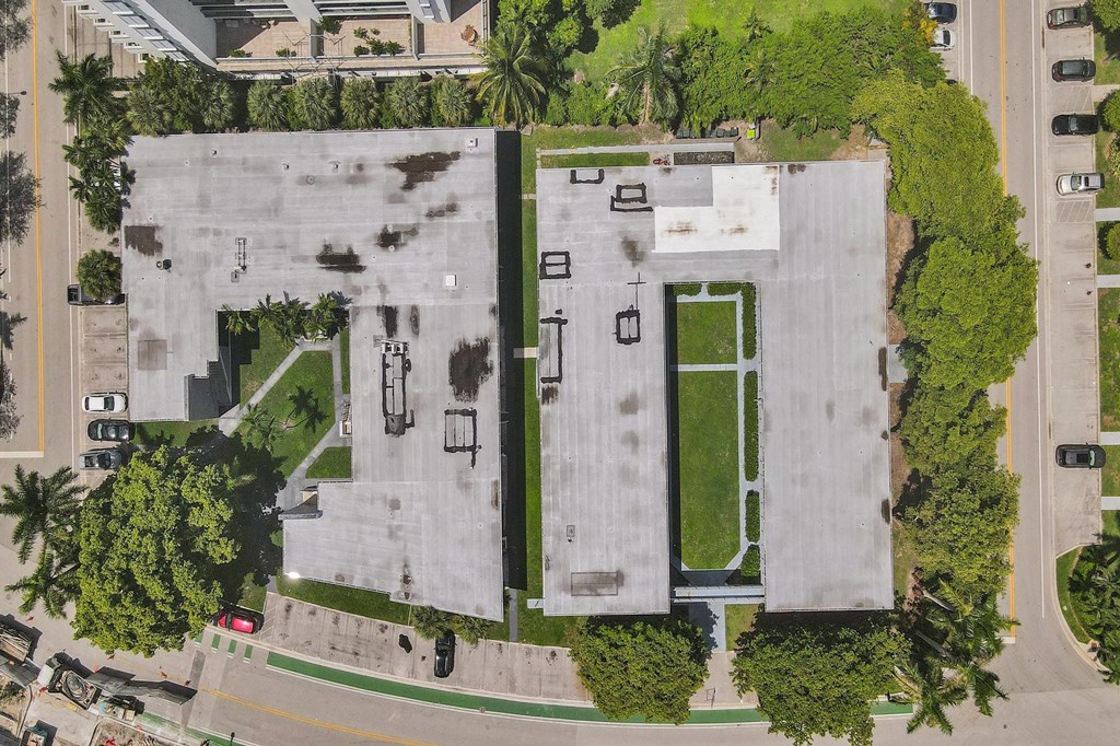 A parking lot with a green field in the middle.