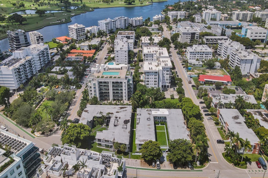 A bird's eye view of a city with buildings, roads, and a body of water.