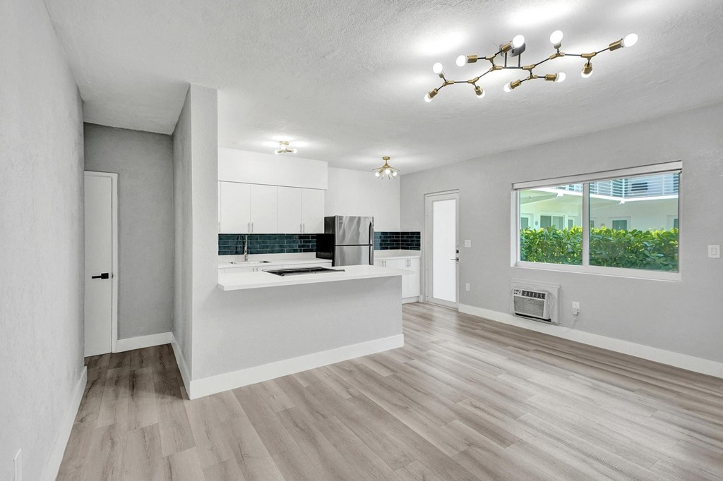 A modern kitchen with a large island and a view of the backyard.