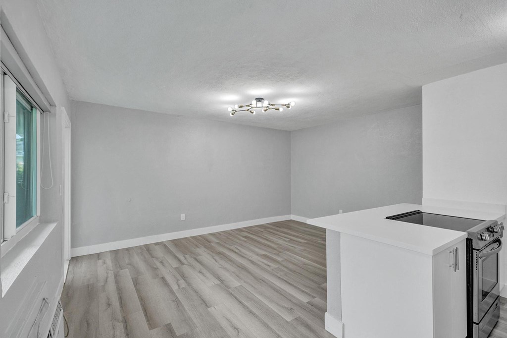A kitchen with a white counter and a window.