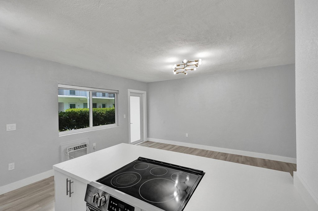 A kitchen with a stove top oven and a window.