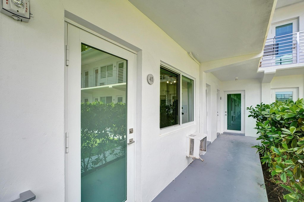 A white building with a glass door and a window.