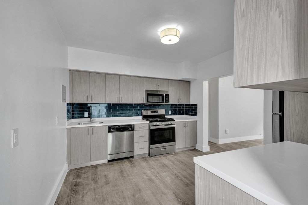 A modern kitchen with stainless steel appliances and wooden cabinets.