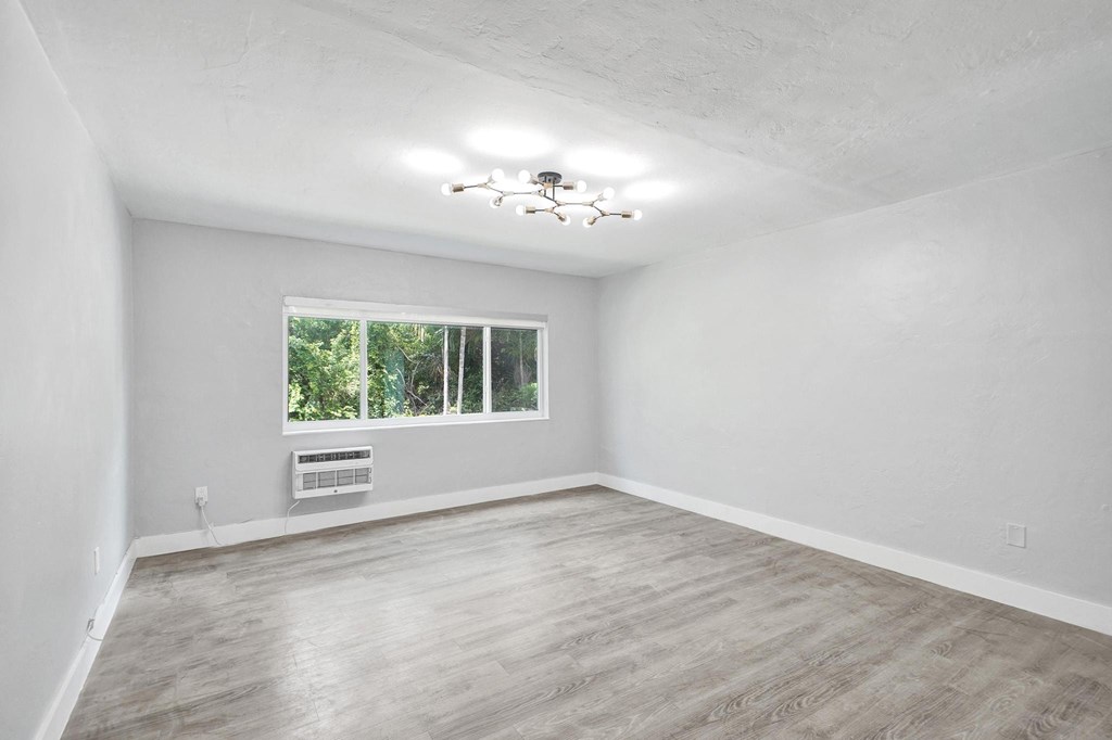 A room with a window and a ceiling fan.