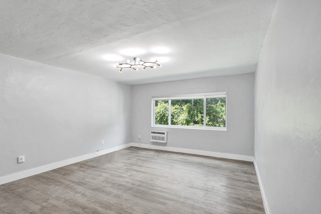 A room with a window and a chandelier.