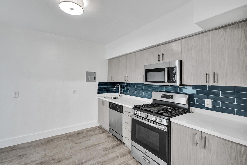 A kitchen with a stove top oven and microwave above it.