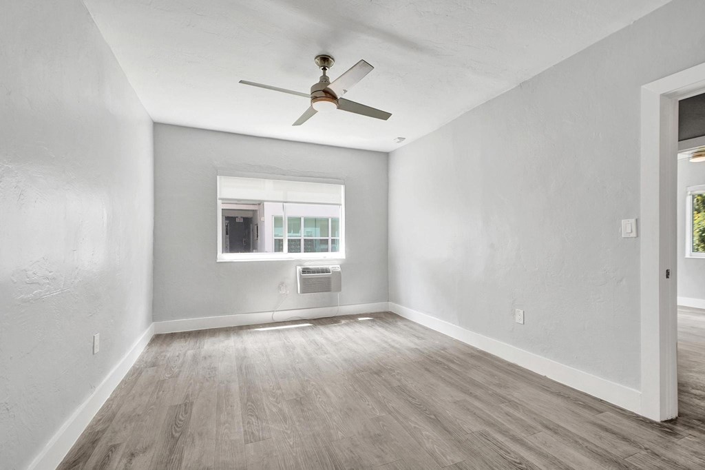 A room with a ceiling fan and a window.