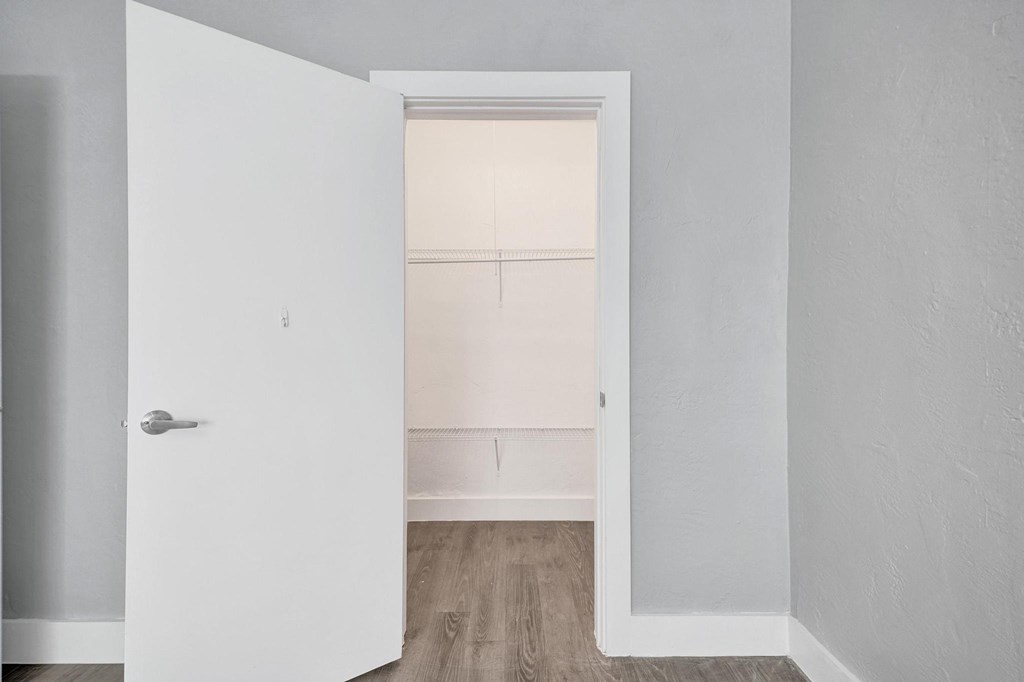 A white door is open to a room with a window.