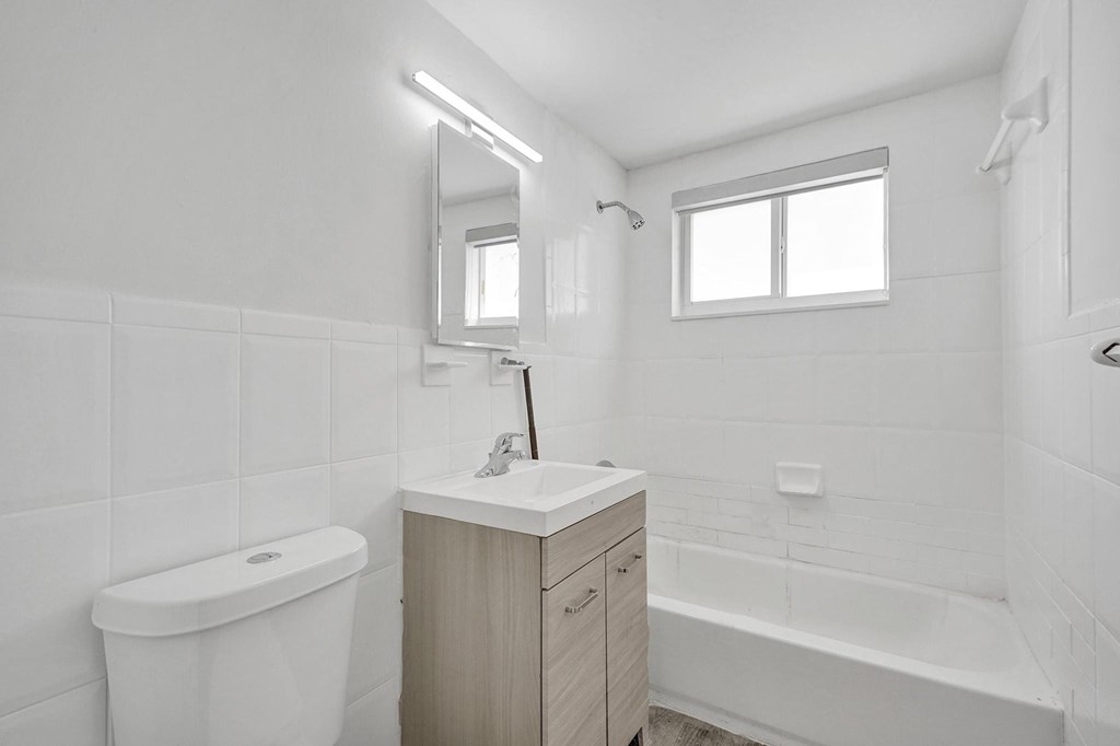 A white bathroom with a toilet, sink, and bathtub.