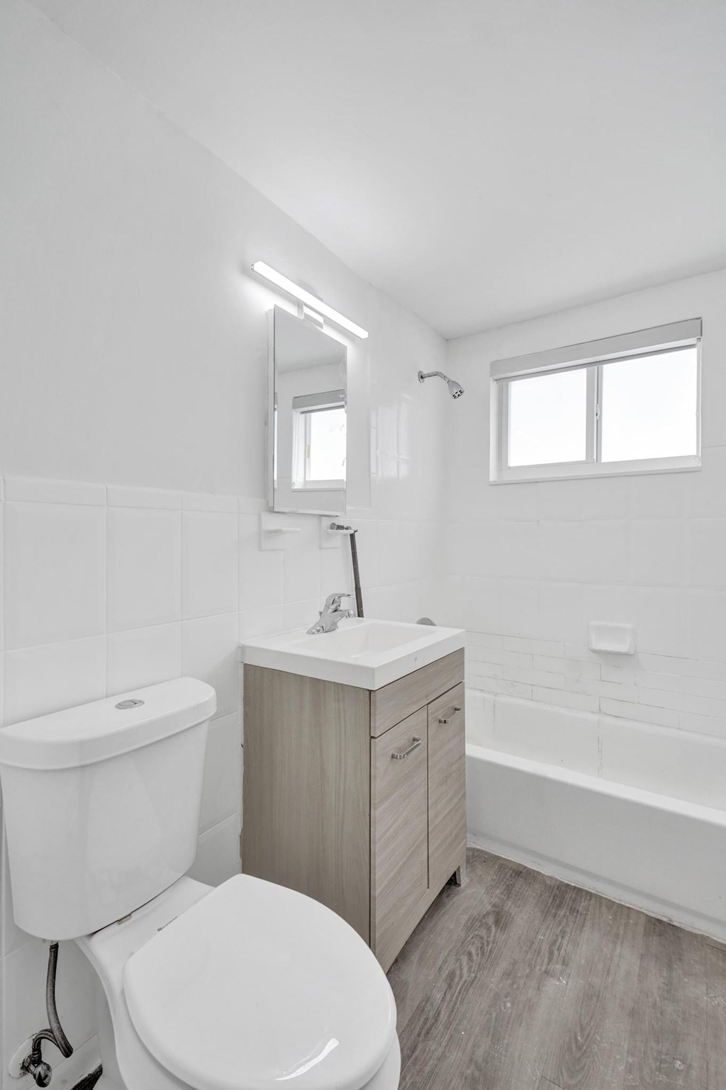 A white toilet sits next to a sink in a small bathroom.