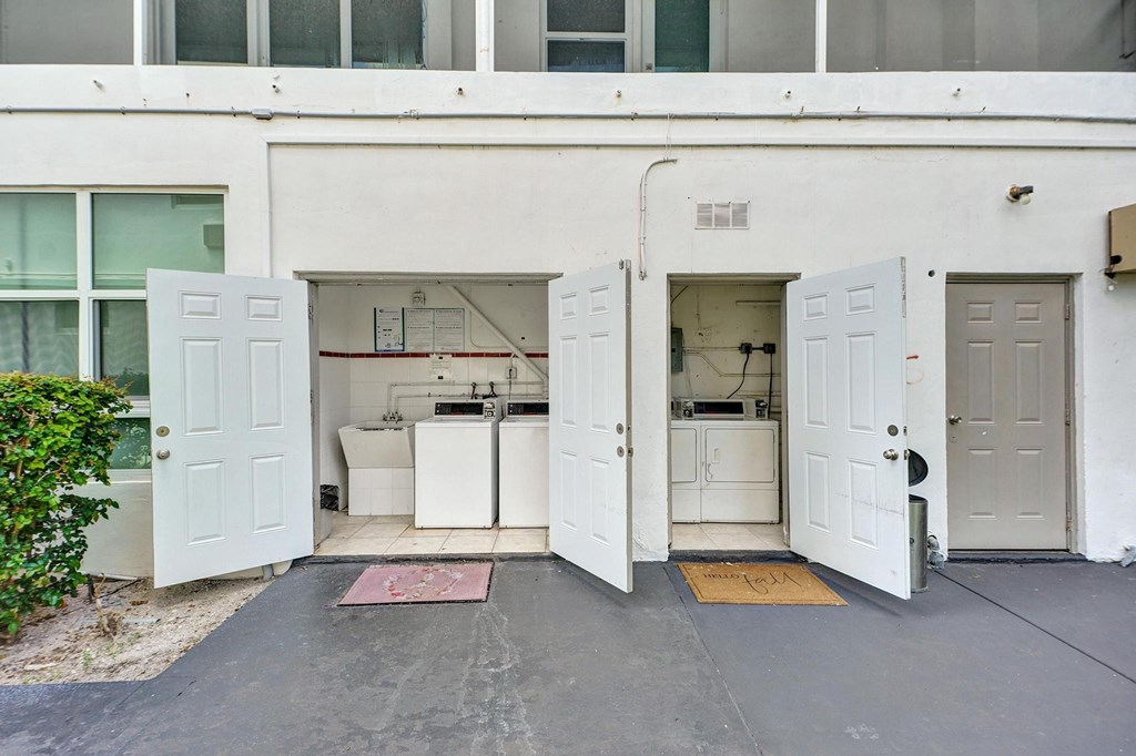 A white building with a garage door open to a white interior.