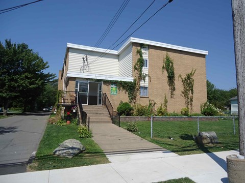 A small building with a white roof and a fence in front.