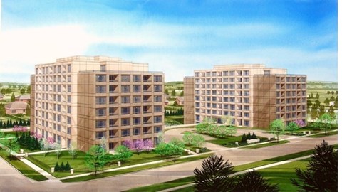 Two identical buildings are surrounded by a green lawn.