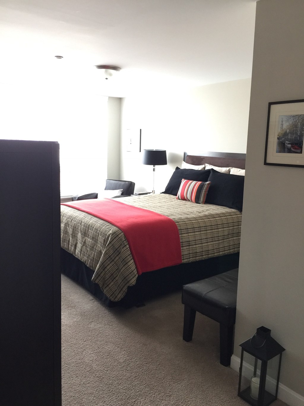 A bedroom with a bed, nightstand, and lamp.