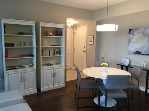 A dining room with a white table and grey chairs.