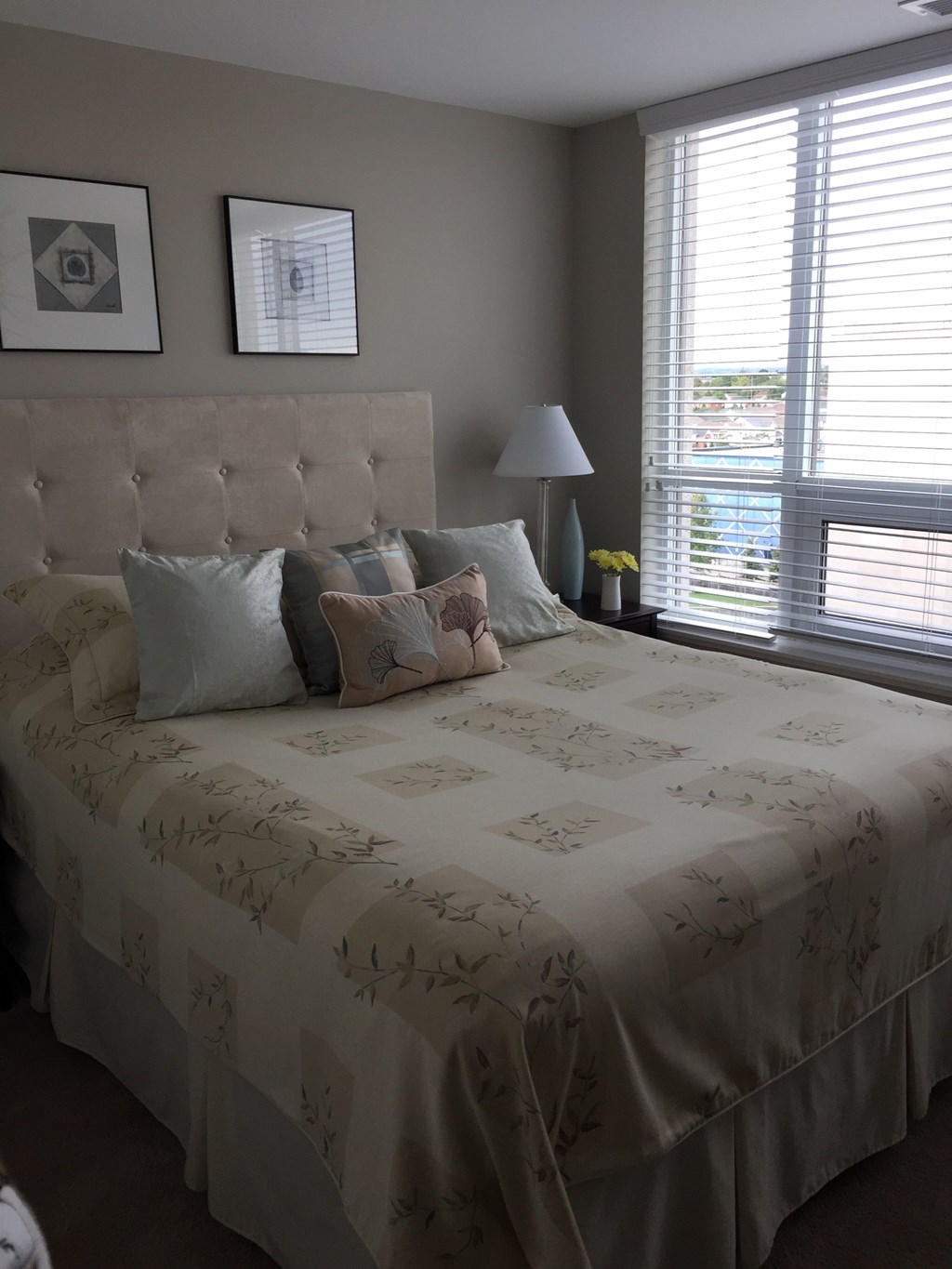 A bed with a tufted headboard and a floral patterned comforter.