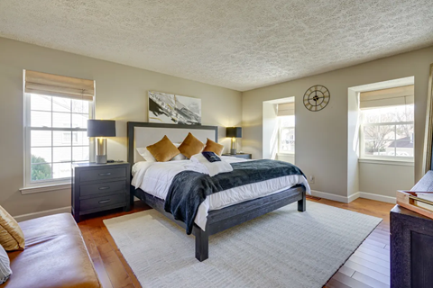 A bedroom with a large bed and a window.