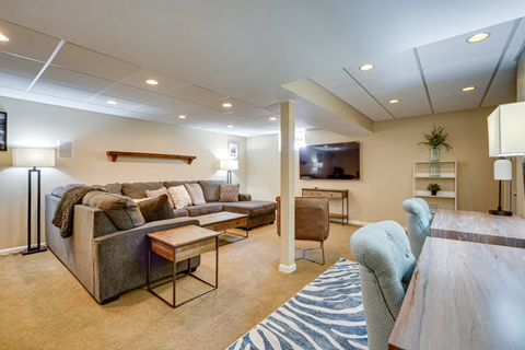 A living room with a grey couch and a wooden coffee table.