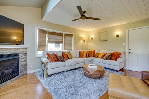 A living room with a white couch and a fireplace.