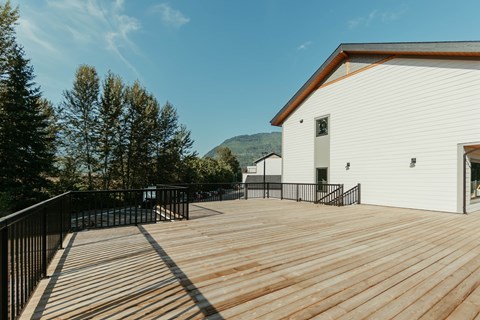 A white building with a wooden deck in front.