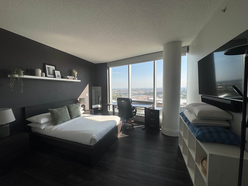 A bedroom with two beds, one of which has a blue plaid blanket.
